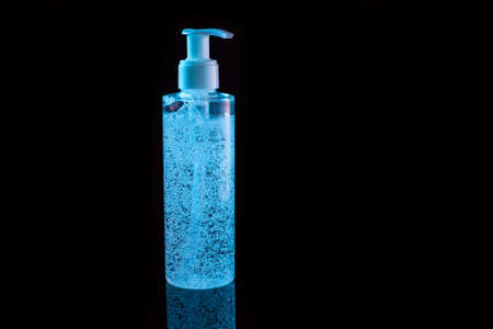 Cosmetic product for makeup remove. Blue liquid with small air bubbles. Bottle with dispenser. On dark surface background.の写真素材