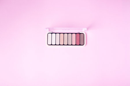 Eyeshadow palette for make up on pink background with copyspace. Rose color cosmetic product flat layの写真素材