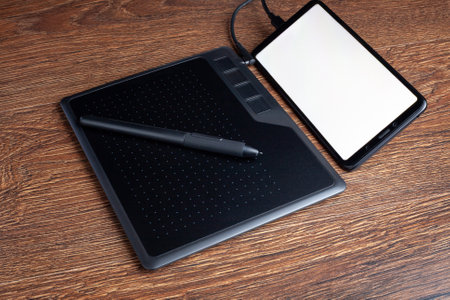 Ggraphic tablet drawing retouching pad with digital pen stylus connected to smartphone with blank white screen copy spaceの写真素材