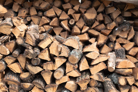 Stacked firewood background. Firewood pattern. Wood saving wall. Stock of wood for kindling a...