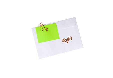 Paper envelope with blank note and dog-shaped paper clip on white background. Office supplies for a good mood. reminder on paper. Close upの写真素材