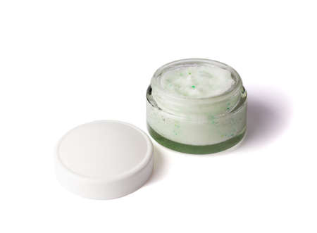 Texture cosmetic scrub for face and body in glass jar with white cap. Body scrub with green crystals. Isolated on white background.の写真素材