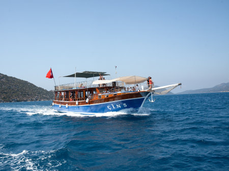 Demre, Turkey - 07.07. Pleasure yacht in the sea. Tourist ship with people on board with turkish flag sails on the waves. Fast moving excursion ship boat.のeditorial素材