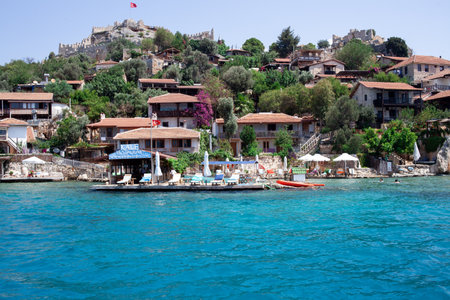 Ancient village of Simena with castle on mountain. Boat dock, beautiful landscape. Sea tour of Lycian underwater city on island of Kekova near Demre. Province Antalya. Kalekoy, Turkey - 07.07.のeditorial素材