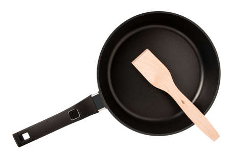 Wooden spatula in frying pan with non-stick coating. Kitchen Utensils isolated on white. Shallow DOF. Selective focus on the food spatula. Top viewの写真素材