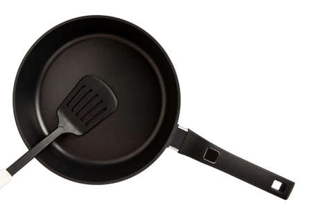 Plastic spatula in frying pan with non-stick coating. Kitchen Utensils isolated on white. Shallow DOF. Selective focus on the spatula. Top viewの写真素材