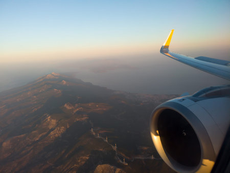 Airplane wing with engine out of window. Flight over land on sunrise. Airplane porthole view....