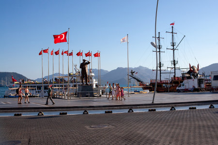 Ataturk square in the center of Marmaris city in Turkey. Tourist people walking embankment passing Ataturk monument. Turkey, Marmaris - September 5, 2021のeditorial素材