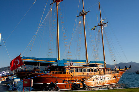 Pleasure yacht in the port. Tourist ship with people on board with turkish flag getting ready to...
