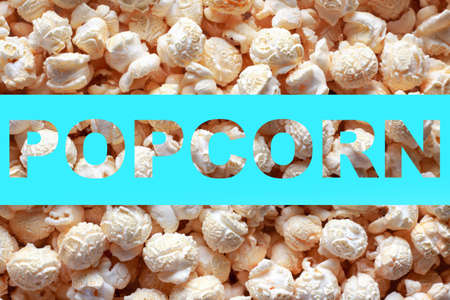 Popcorn texture background with inscription POPCORN. Word POPCORN on blue background. Cinema poster concept.の写真素材