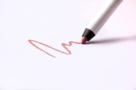 Cosmetic pencil and stroke isolated on white. Make-up pencil red strokes on white paper. Macro photoの写真素材