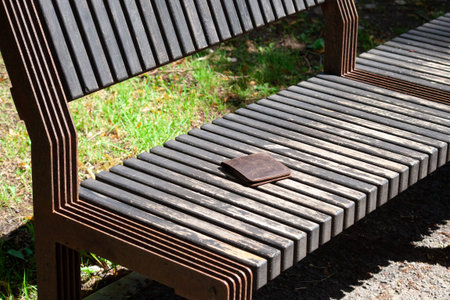 Forgotten wallet on the wooden bench in the city park. lost Purse in the park