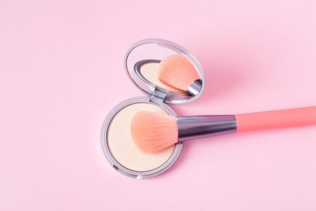 Beautiful eyeshadow palette with makeup brush lie on the pink background top view. makeup product.