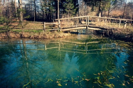 Wooden bridge over the river, in autumnの写真素材