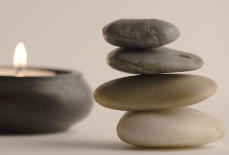 Stack of balanced stones and candle. Selective focus. の写真素材