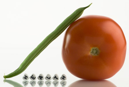 Tomato, bean and the word HEALTH spelled with -shaped beads on white background
