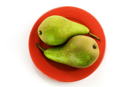 Two green pears on a red plate over whiteの写真素材