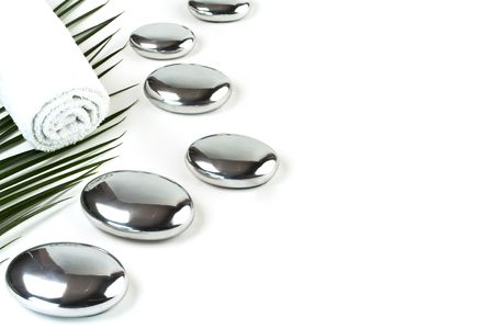 metal pebbles,towel and palm leaf over white. Selective focus.の写真素材