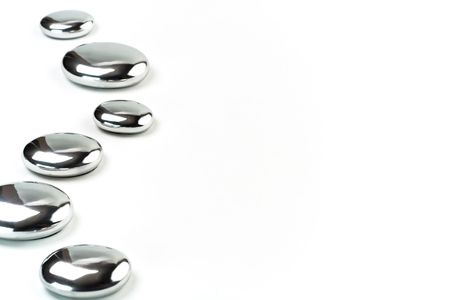 Six metal pebbles on white background. Selective focus. の写真素材