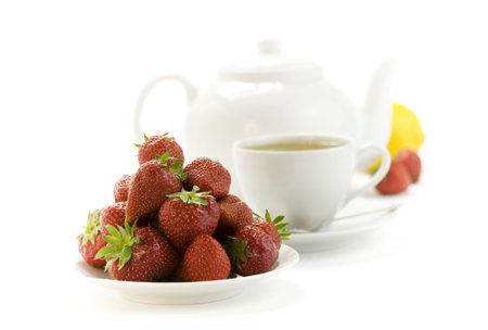 strawberry, lemon, teapot and white teacup with hot tea on white backgroundの写真素材