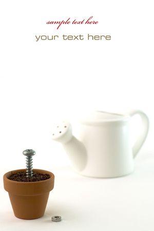 Watering can and screw in the pot. Isolated on white.With sample textの写真素材