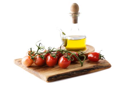 Bottle of olive oil and tomatoes over whiteの写真素材
