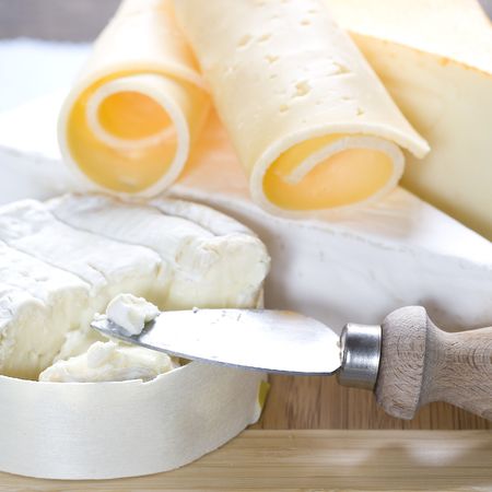 Cheese still life on a wooden boardの写真素材