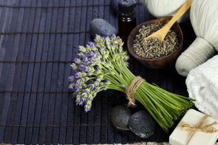 Fresh  and dried lavender flowers, zen stones, essential oii and  Herbal massage balls over wooden surfaceの写真素材