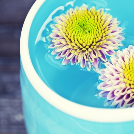 bowl of water and flowers on a wooden surface, Spa and healthcare concept. の写真素材