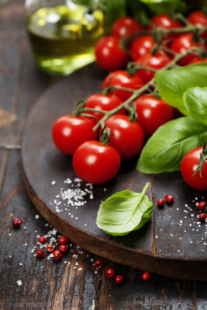 Tomatoes with basil on wooden table background. Food composition. の写真素材