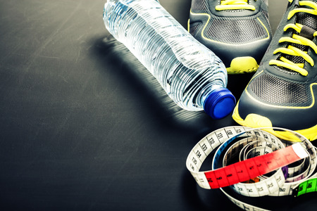 Sport shoes, measuring tape and water on grey backgroundの写真素材