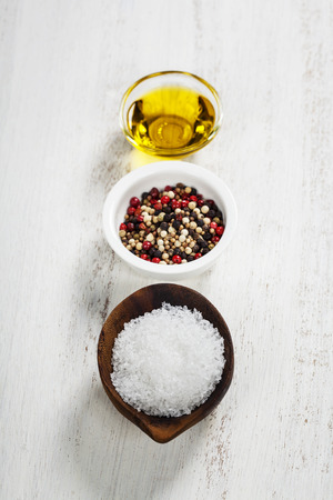Salt, pepper and olive oil on a wooden boardの写真素材