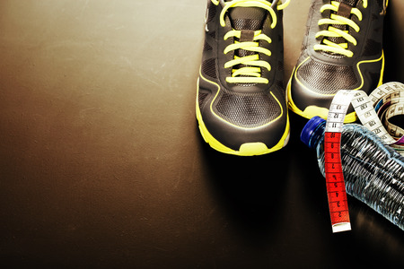 Sport shoes, measuring tape and water on grey backgroundの写真素材