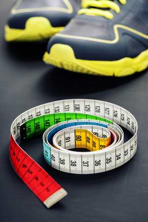 Sport shoes and  measuring tape on grey backgroundの写真素材