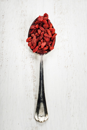 Metal tablespoon of dried goji berries on wooden backgroundの写真素材