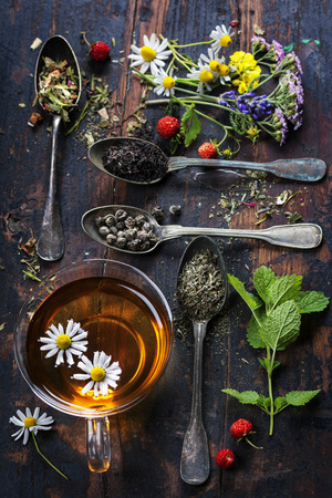 Various kinds of tea  with honey, wild berry and flowers on wooden backgroundの写真素材