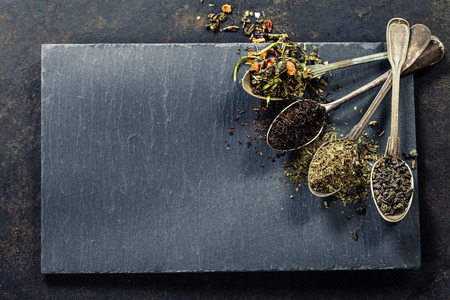 Tea composition with Different kind of tea and old spoons on dark backgroundの写真素材