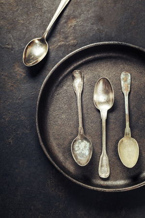 Empty pan with old spoons top viewの写真素材