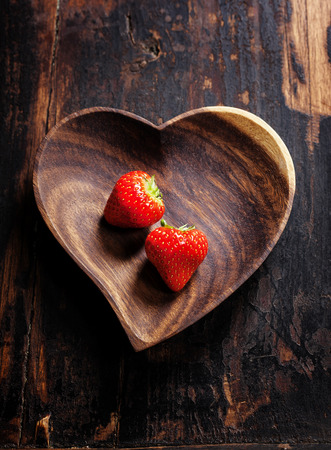 heart shape plate with strawberries on wooden table - Valentine's day conceptの写真素材