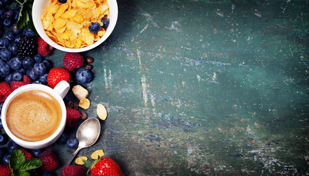 Healthy Breakfast with coffee, corn flakes, milk and berry on old wooden background. Health and diet conceptの写真素材