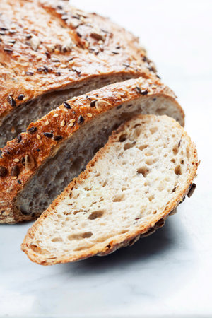 Freshly baked traditional bread on white marble background