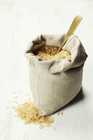 Natural brown rice in small  sack - cooking, healthy eating or vegetarian conceptの写真素材