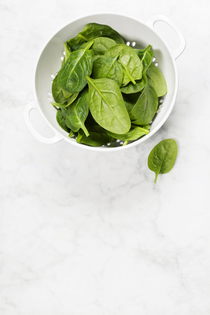raw fresh spinach in a colanderの写真素材