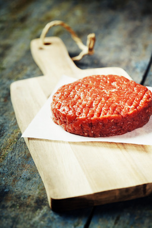 Raw Ground beef meat Burger steak cutlet on vintage wooden boardsの写真素材