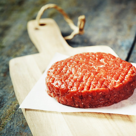 Raw Ground beef meat Burger steak cutlet on vintage wooden boardsの写真素材