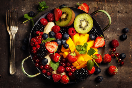 fresh summer fruits and berries on plate, above, rustic backgroundの写真素材