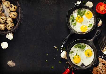 Pans with fried eggs, tomatoes and bread on old metal background, top view. Food. Breakfast. Healthy food.の写真素材