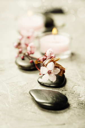 Spa setting. Massage stones, Sea salt, candles and flowers on rustic backgroundの写真素材