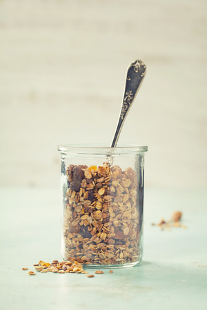 Homemade granola on rustic table. Healthy breakfast of oatmeal, muesli, nuts, seeds and dried fruit.の写真素材