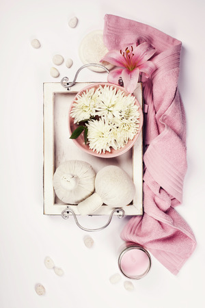 Spa setting with floating flowers and body care and cosmetic tools on shabby chic white background, top view. Wellness conceptの写真素材